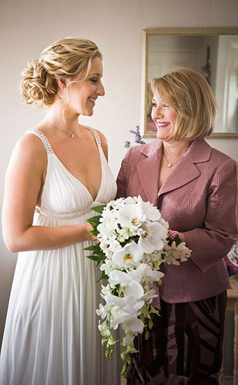 Bride with a beach styled wedding theme getup talking to a woman in a formal suit